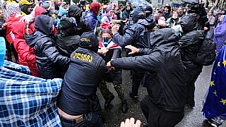 Police try to detain demonstrators near the Parliament building during an opposition protest against "the Russian law" in Tbilisi, Georgia, on Monday, May 13, 2024.