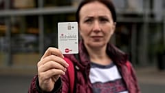 Eine Frau hält ihre Bezahlkarte in die Kamera.