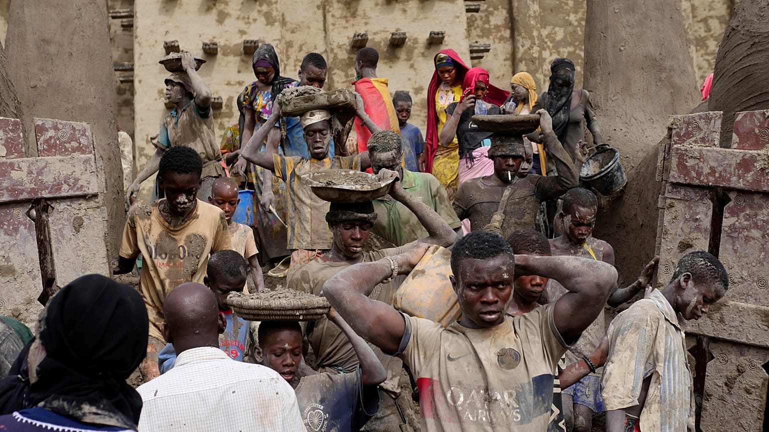 Malians take part in the annual replastering of the world's largest mud-brick building, the Great Mosque of Djenne, Mali, Sunday, May 12, 2024. 