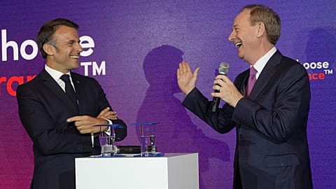 Microsoft CEO Brad Smith, right, speaks to French President Emmanuel Macron at the French Microsoft headquarters in Issy-les-Moulineaux, outside Paris. May 13, 2024. 