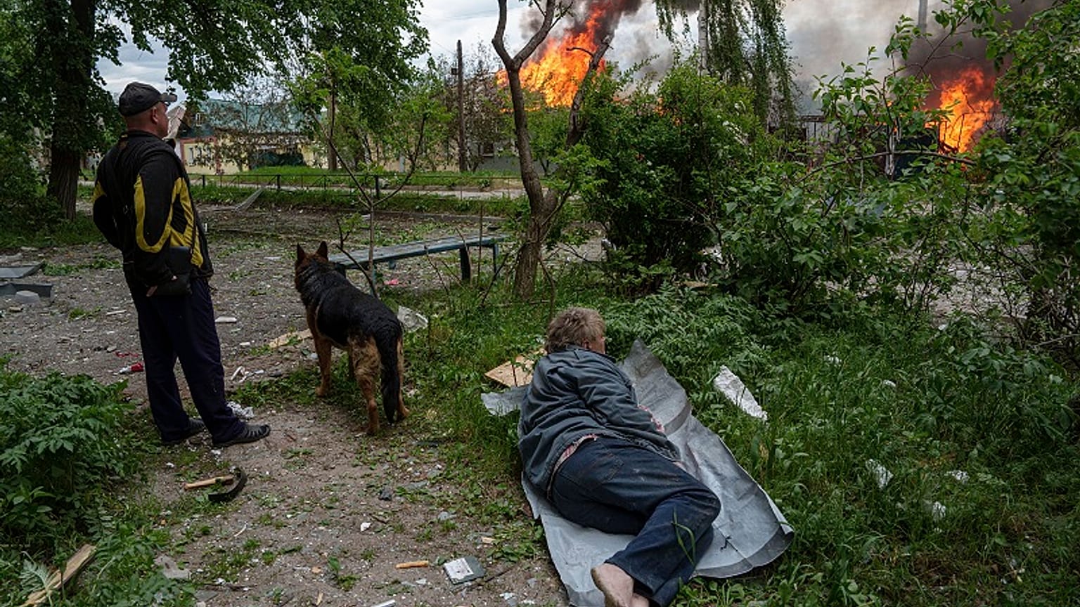 Un hombre yace en el suelo mientras observa su casa en llamas destruida por un ataque aéreo ruso en Vovchansk, Ucrania, el sábado 11 de mayo de 2024.