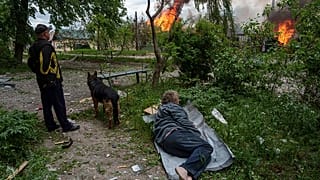 Un hombre yace en el suelo mientras observa su casa en llamas destruida por un ataque aéreo ruso en Vovchansk, Ucrania, el sábado 11 de mayo de 2024.