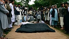 Los cadáveres de afganos son colocados en el suelo después de las fuertes inundaciones en la provincia de Baghlan, en el norte de Afganistán, el 11 de mayo de 2024.