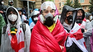 Demonstranten mit Gasmasken stehen in der Nähe des Parlamentsgebäudes während einer Protestaktion der Opposition gegen das "russische Gesetz" im Zentrum von Tiflis, Georgien, am Montag, 13. Mai 2024