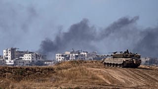 Gazze sınırında bulunan bir İsrail tankı ve kentin içinde bombardıman sonrası yükselen siyah dumanlar