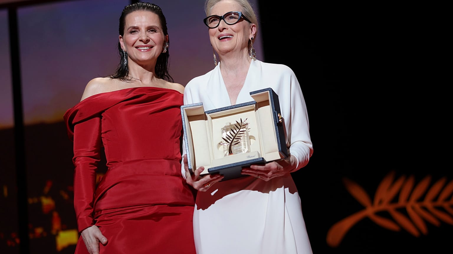 Meryl Streep, au centre, tient la Palme d'Or honorifique, aux côtés de Juliette Binoche, membre du jury, à gauche, lors de la cérémonie d'ouverture du 77e Festival de Cannes