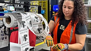 An employee prepares online orders in a distribution center.