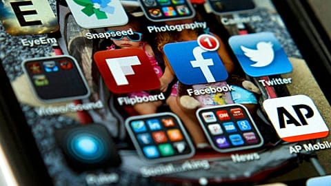 3 file photo shows an iPhone in Washington with Twitter, Facebook, and other apps. 