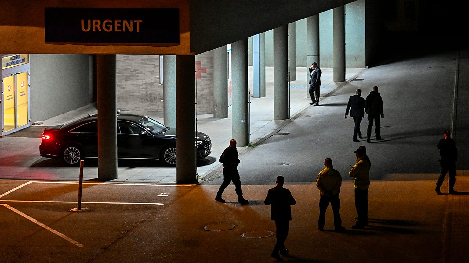 Police and officials stand outside the entrance of the emergency room of the Roosevelt Hospital in Banska Bystrica, 15 May 2024