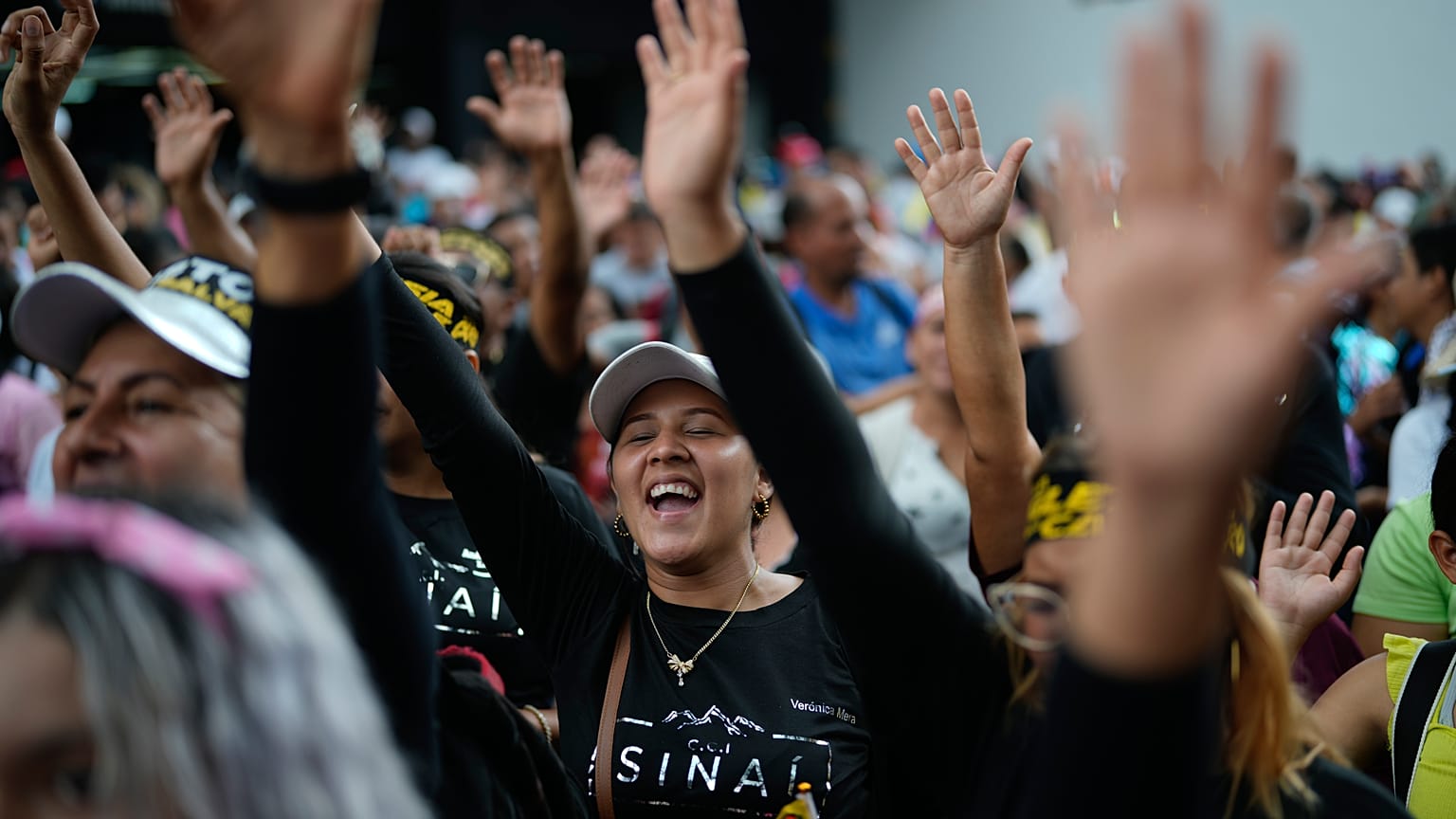 Evangelical Christinas raise their hands in prayer during a march in defense of the original family model marking Family Day