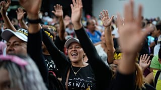 Evangelical Christinas raise their hands in prayer during a march in defense of the original family model marking Family Day