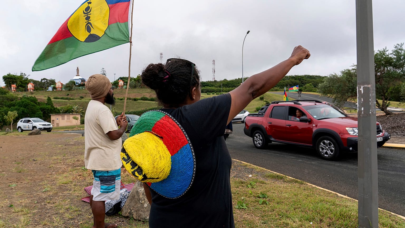 Eine Frau schwenkt am Mittwoch, den 15. Mai 2024, in Noumea, Neukaledonien, eine Flagge der Sozialistischen Nationalen Befreiungsfront (FLNKS).