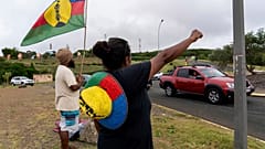 Eine Frau schwenkt am Mittwoch, den 15. Mai 2024, in Noumea, Neukaledonien, eine Flagge der Sozialistischen Nationalen Befreiungsfront (FLNKS).