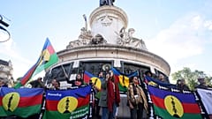 Manifestantes sostienen banderas canacas y del Frente Socialista de Liberación Nacional (FLNKS) durante una concentración en París
