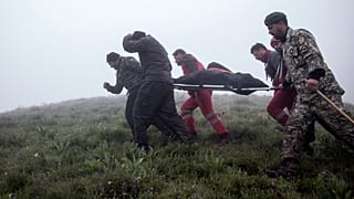 Cumhurbaşkanı Reisi'nin cesedi, kurtarma ekipleri tarafından taşınıyor