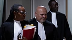 DATEI - Staatsanwalt Karim Khan, Mitte, betritt den Gerichtssaal für den Prozess gegen Mahamat Said Abdel Kani am IStGH in Den Haag, Niederlande, Montag, 26. September 2022.
