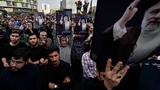 People hold up posters of Iranian President Ebrahim Raisi during a mourning ceremony for him at Vali-e-Asr square in downtown Tehran, Iran, Monday, May 20, 2024.