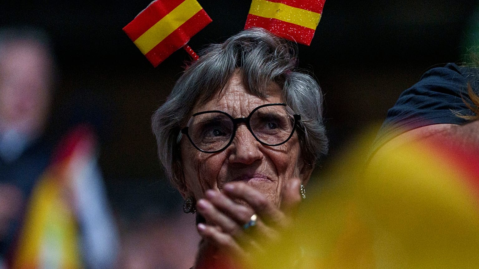 Uma apoiante com uma bandeira espanhola na cabeça participa num comício do partido de extrema-direita espanhol Vox "Europa Viva 24" em Madrid, Espanha, no domingo, 19 de maio 