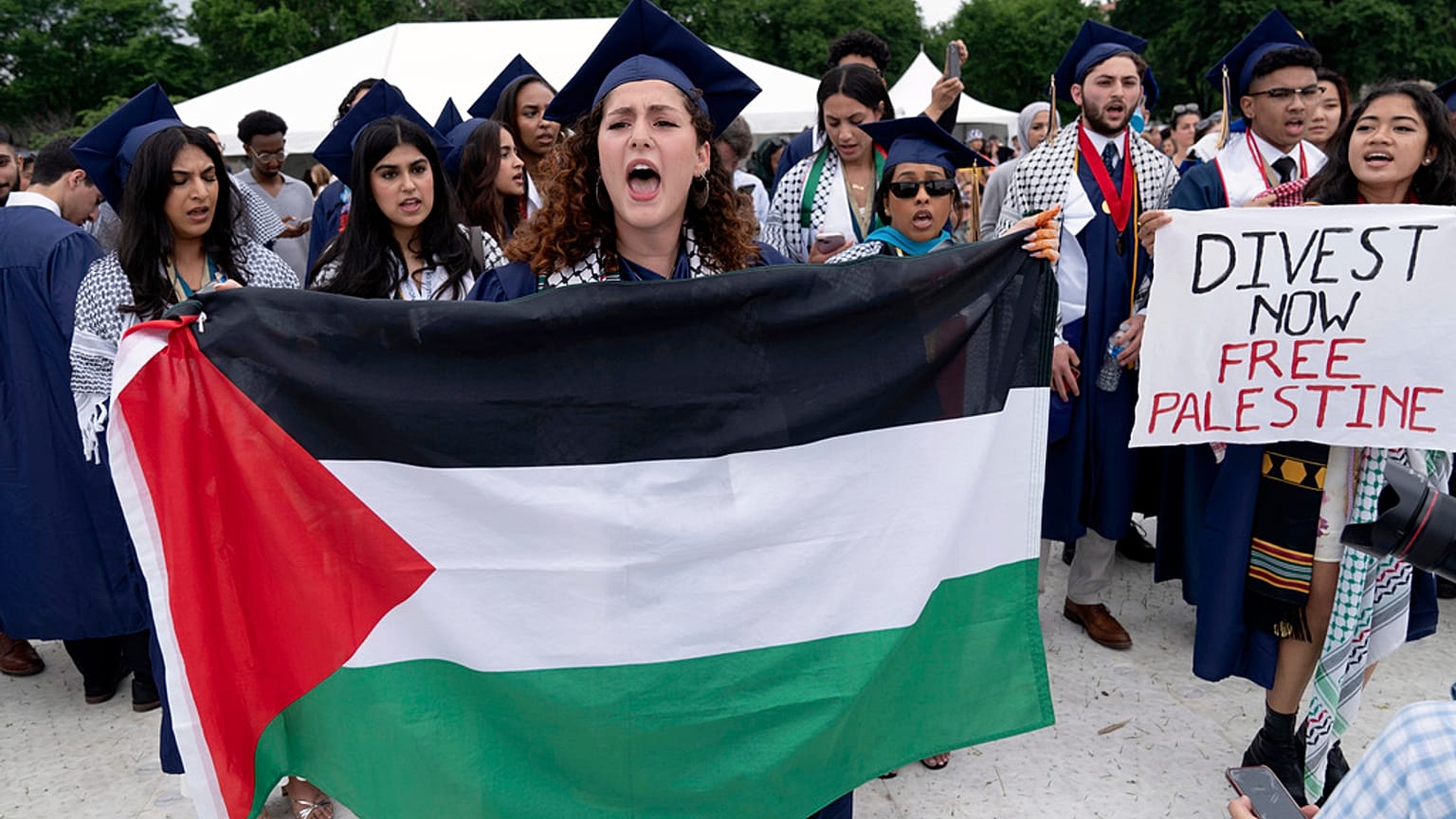 طلاب جامعة جورج واشنطن يحملون العلم الفلسطيني خلال احتجاج مؤيد للفلسطينيين في حفل التخرج في واشنطن، 19 مايو، 2024.