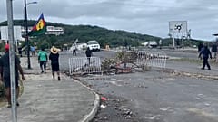 Des habitants tentent de déblayer les débris dans les rues de Nouméa.
