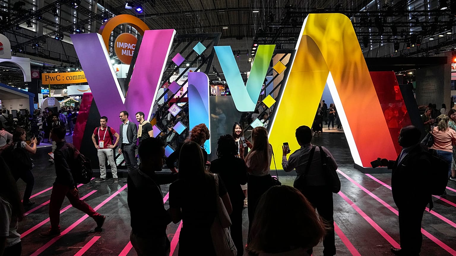 Os espectadores posam para fotografias em frente ao logótipo da Vivatech no salão Vivatech em Paris, quinta-feira, 15 de junho de 2023