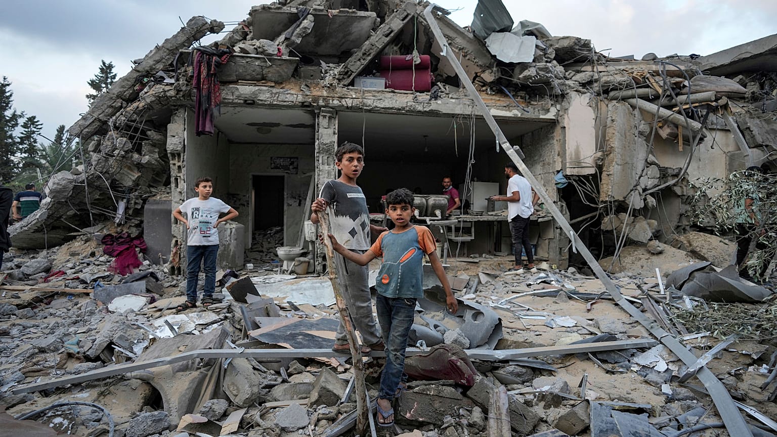 أطفال يقفون على أنقاض المنازل المدمرة في غزة