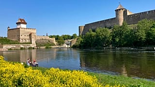 Dos hombres pescan cerca del castillo de Narva, en el río del mismo nombre que ejerce de frontera natural entre Estonia y Rusia, el miércoles 24 de mayo de 2023.