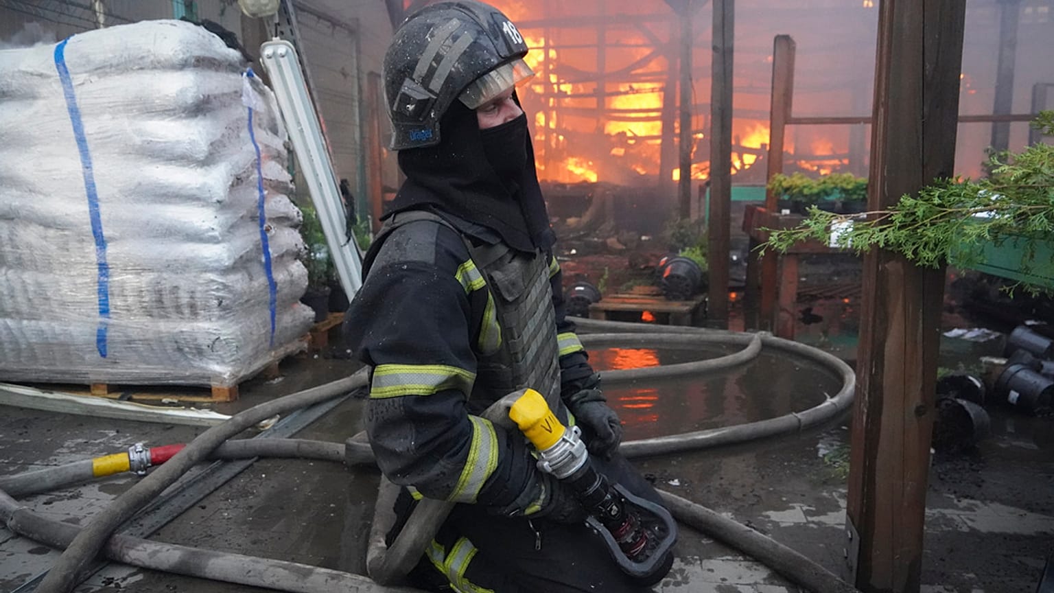 Bombero apagando fuego después de que un misil guiado alcanzase un almacén de suministros en Járkov