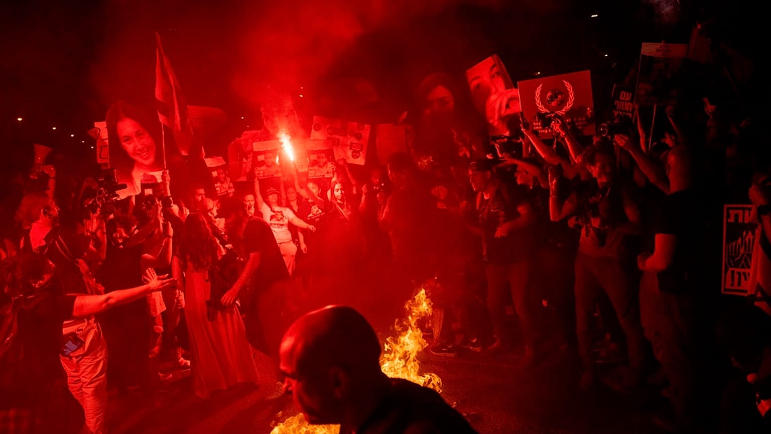 Demonstrators burn fire during a protest against Israeli Prime Minister Benjamin Netanyahu's government, and calling for the release of hostages held in the Gaza Strip by the 