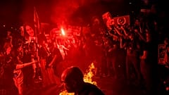 Manifestantes queimam fogo durante um protesto contra o governo do primeiro-ministro israelita Benjamin Netanyahu e apelam à libertação dos reféns detidos na Faixa de Gaza pelo 