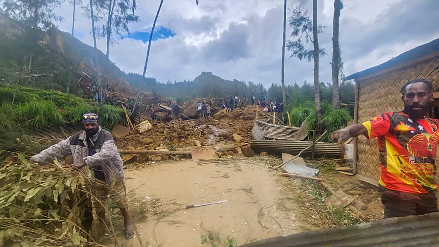 Villagers search through a landslide in Yambali 