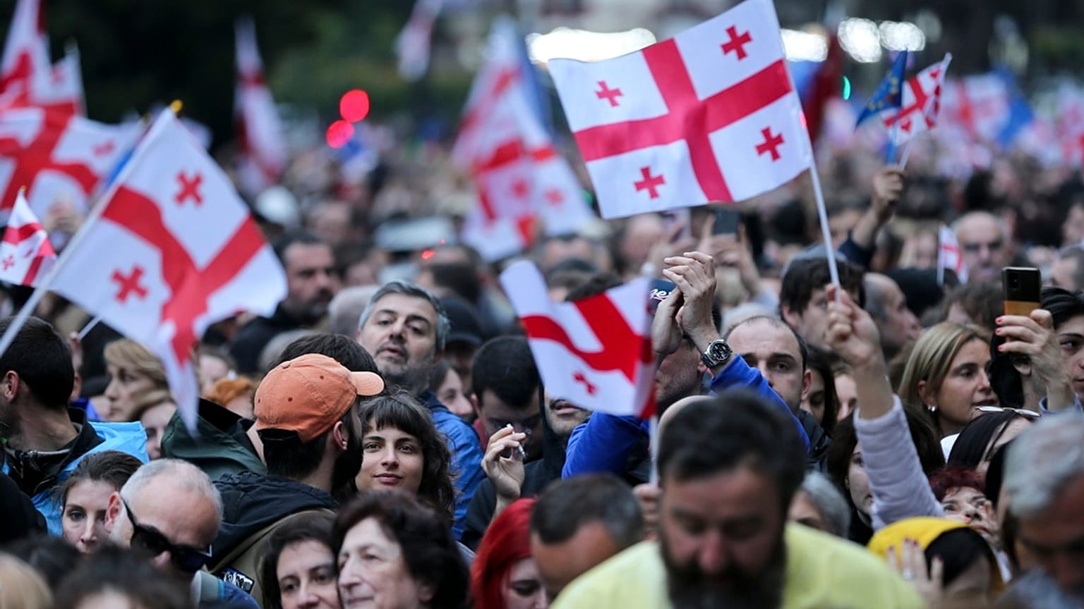 Demonstranten mit georgischen Nationalflaggen versammeln sich während eines Protestes im Zentrum von Tiflis, Georgien, Sonntag, 26. Mai 2024. 