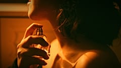 Woman spraying perfume.