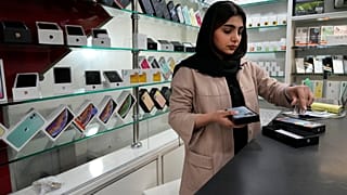 یک فروشنده تلفن همراه در مغازه‌اش در مرکز شهر تهران