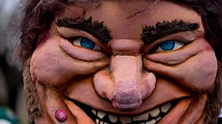 A large puppet of Argentine President Javier Milei is held by a protester outside a government depot for food storage where people gather to demand the release of supplies for