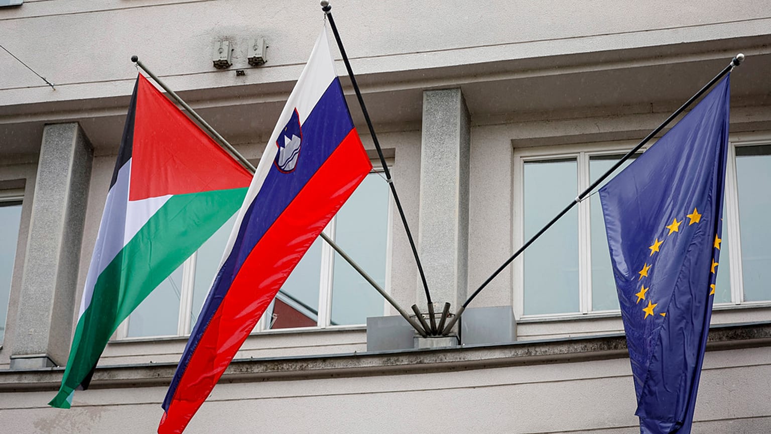 Slovenya'nın Ljubljana kentindeki hükümet binasında, ortada bir Sloven ve sağda bir Avrupa Birliği bayrağının yanında bir Filistin bayrağı dalgalanıyor, 30 Mayıs 2024 