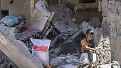 فتى فلسطيني يجلس على أنقاض منزله المدمر في جباليا 