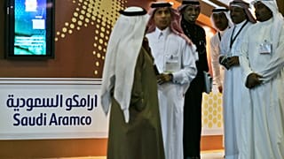 Employees of the Saudi Aramco oil company prepare for the first day of the Arab Oil and Gas exhibition in Dubai