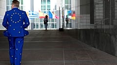 Ein Mann trägt einen Anzug in den Farben der EU, als er vor dem Europäischen Parlament spazieren geht