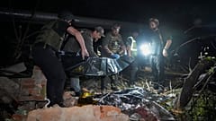 Polizisten bedecken eine Leiche nach dem russischen Raketenangriff auf ein Wohnhaus in Charkiw, 31. Mai 2024