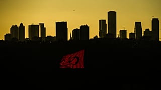 FILE - The sun sets behind high buildings of a financial business area in Istanbul, Turkey, Friday, March 22, 2024.