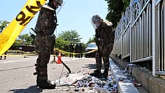 Dél-koreai katonák védőfelszerelésben ellenőrzik egy feltehetően Észak-Koreából érkezett léggömb tartalmát - Incsihon, 2024.06.02.
