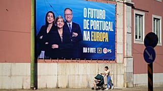Pessoas caminham à porta do Parlamento Europeu antes de um debate com os principais candidatos às eleições para o Parlamento Europeu em Bruxelas.