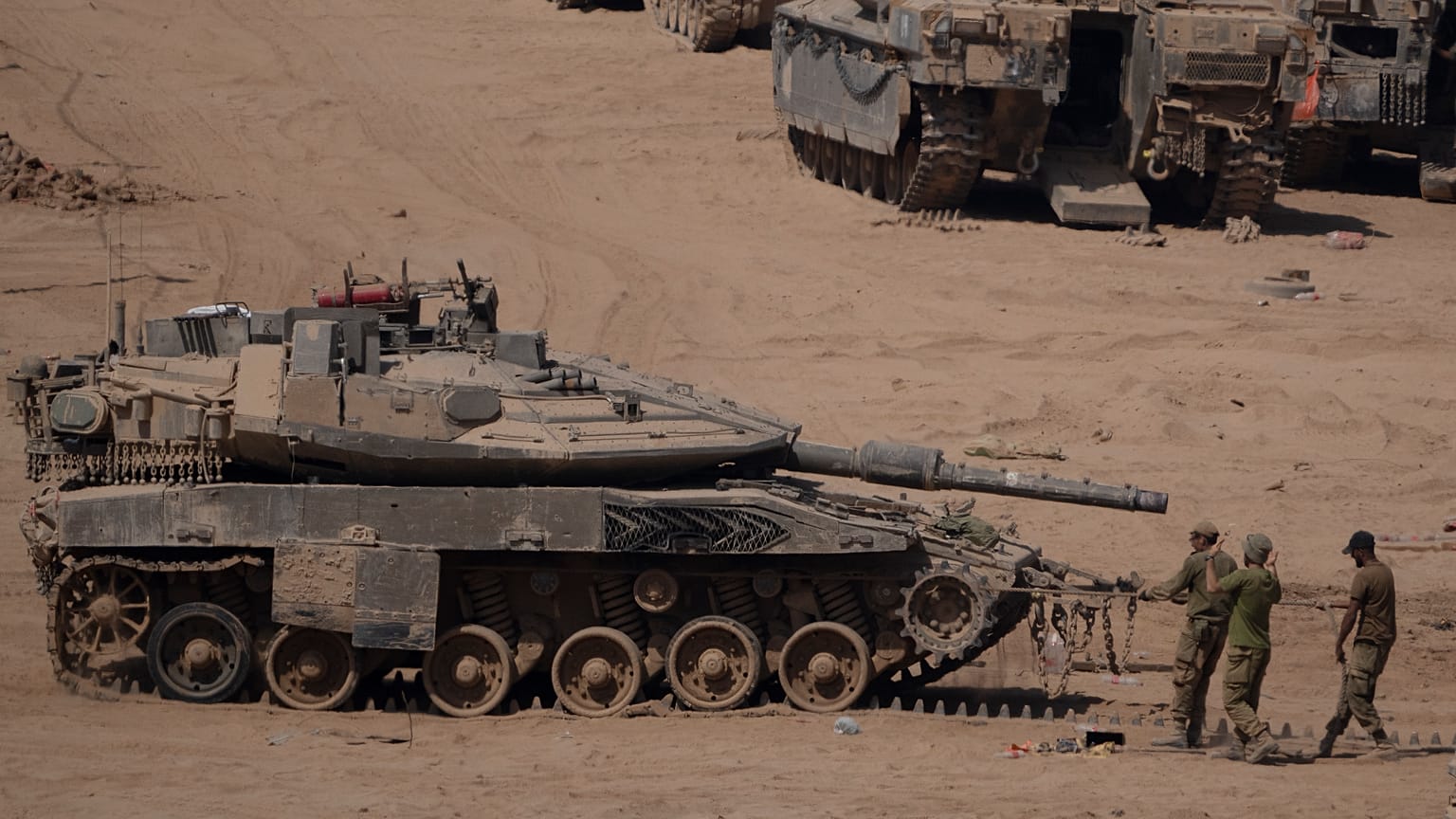 Israeli soldiers work on a tank in a staging area near the Israeli-Gaza border in southern Israel, Monday, June 3, 2024. 