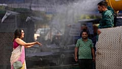 A polling official enjoys a cooling spray of water under intense heat on the eve of the fifth phase of polling in national election in Lucknow, India, Sunday May 19, 2024.