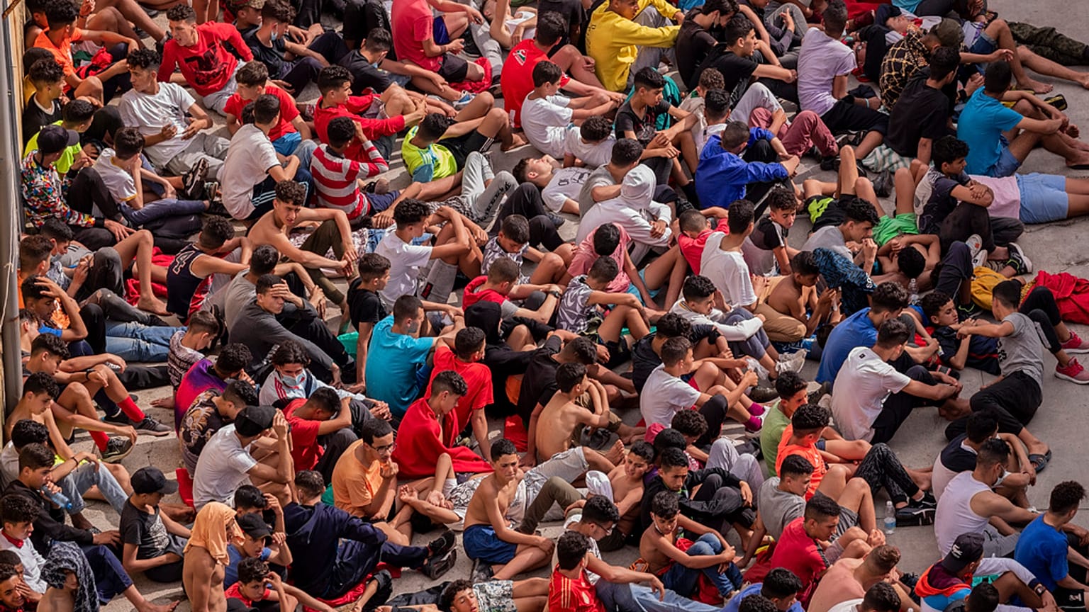 Menores no acompañados que cruzaron a España se reúnen fuera de un refugio temporal en Ceuta, cerca de la frontera entre Marruecos y España, miércoles 19 de mayo de 2021.