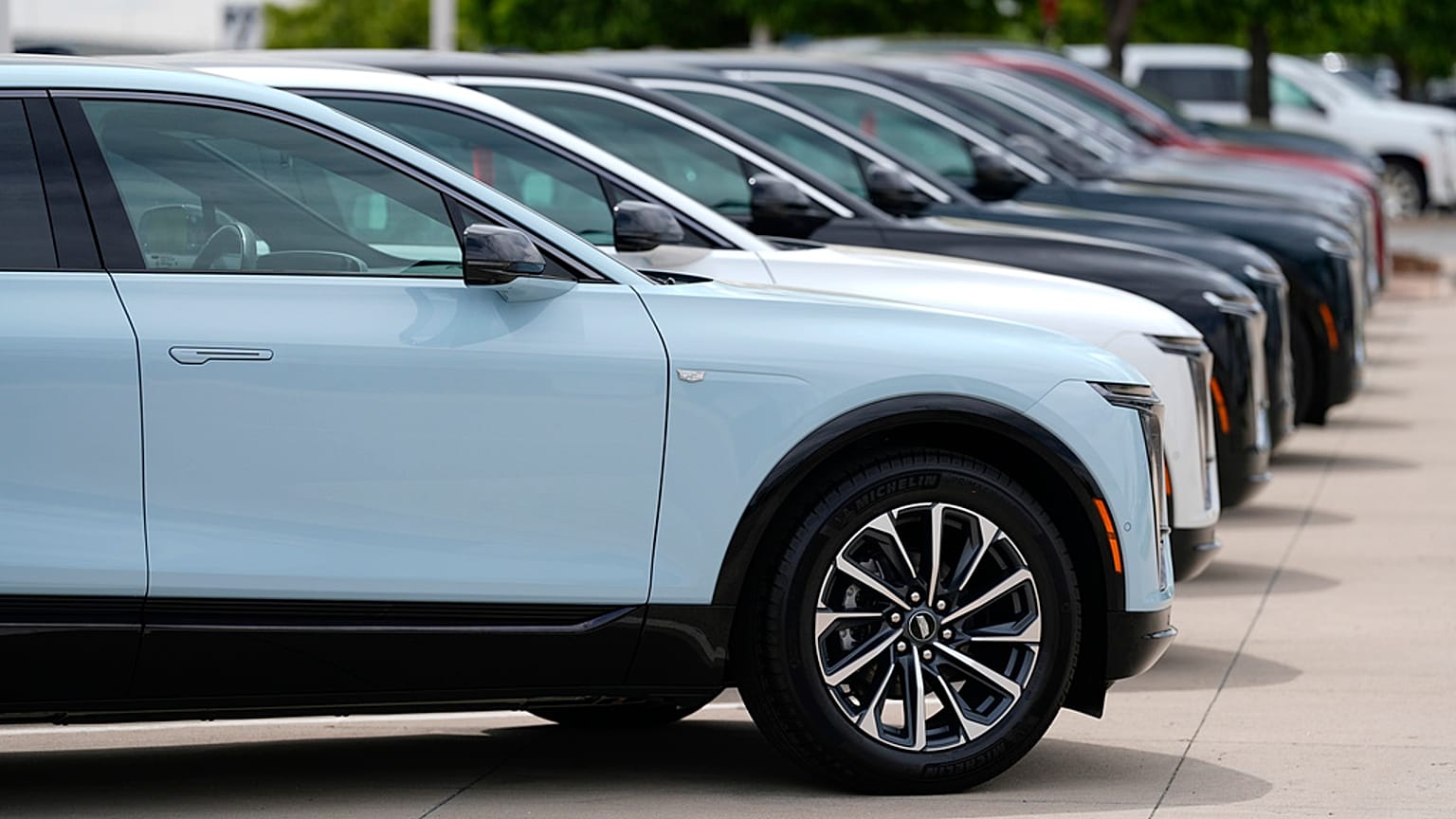Unverkaufte 2024 elektrische Lyriq-Nutzfahrzeuge stehen in einer Reihe vor einem Cadillac-Händler am Sonntag, 2. Juni 2024, in Lone Tree, Colo. (AP Photo/David Zalubowski)