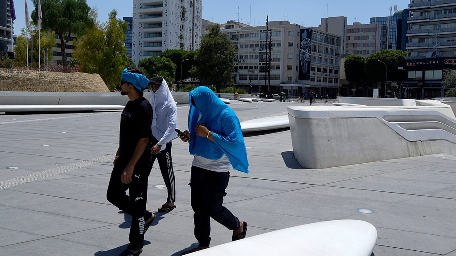 Περαστικοί προσπαθούν να προστατευτούν από τον καύσωνα στην πλατεία Ελευθερίας στην Λευκωσία