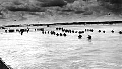 In this June 1944, file photo, U.S. reinforcements wade through the surf as they land at Normandy.