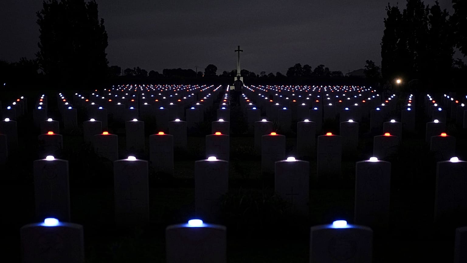 Luzes acesas em cada lápide no cemitério de Banneville-La-Campagne, Normandia, França, durante uma cerimónia do 80º aniversário do Dia